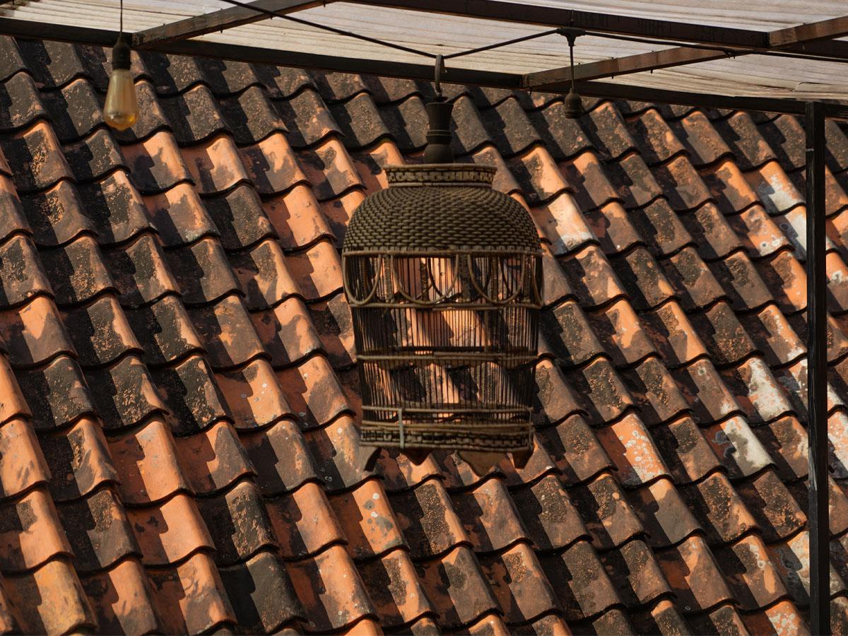 Clay roof tiles with a rattan birdcage lantern.