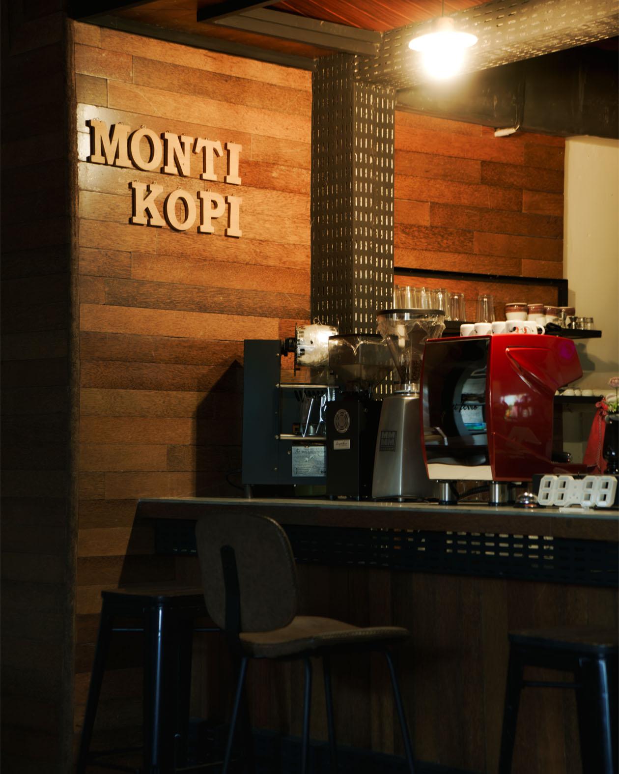 The Monti Kopi wooden counter with a red espresso machine.
