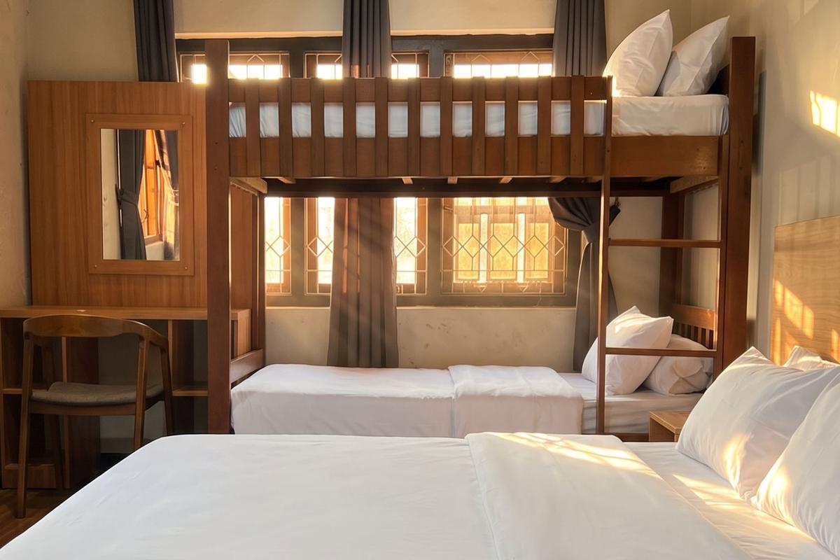 Deluxe 4P room with a wooden bunk bed and a double bed by the window.